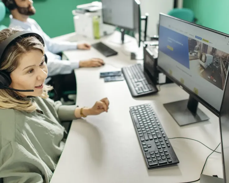 Woman with headset working at a desktop computer